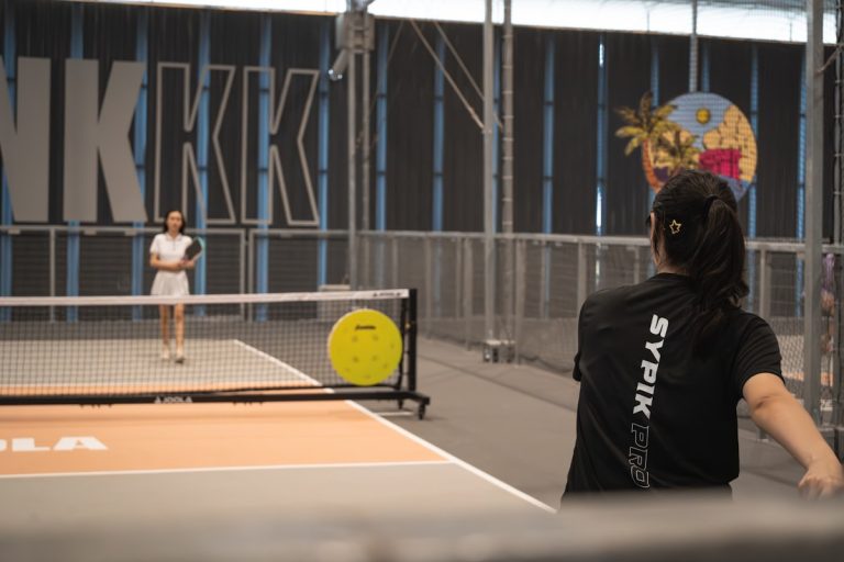 Two people playing an indoor paddle sport